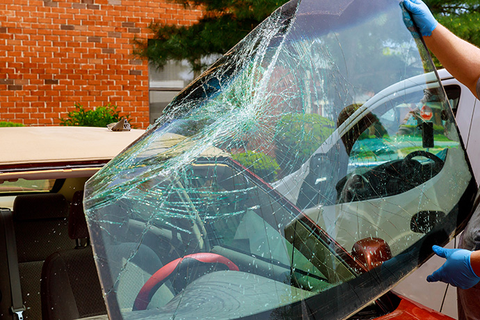 a shattered windshield being removed