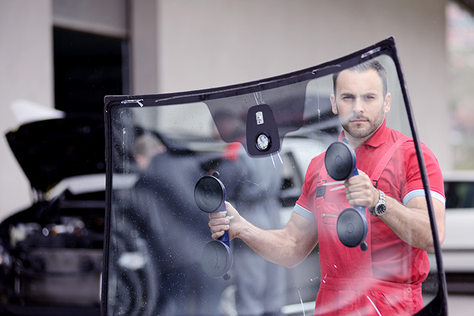 man carrying a windshield for installation